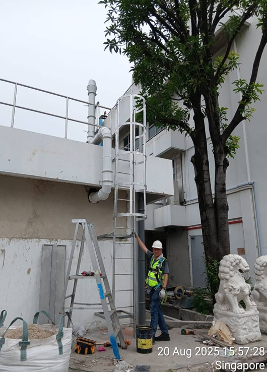 Worker installing new galvanised cat ladder with safety cage